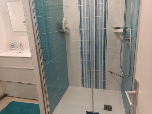 une douche avec une porte vitrée dans une salle de bain dans l'établissement Spacieux T2 à Hendaye avec parking à deux pas de la plage - FR-1-239-794, à Hendaye