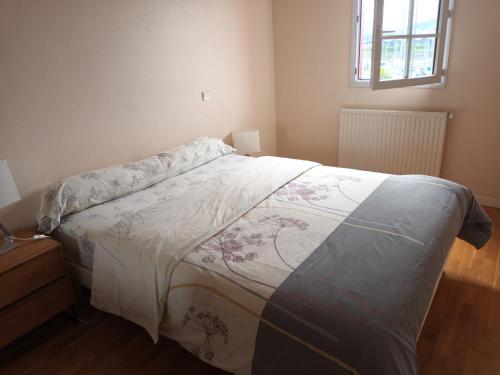 une chambre avec un lit avec une couverture dessus dans l'établissement Spacieux T2 à Hendaye avec parking à deux pas de la plage - FR-1-239-794, à Hendaye