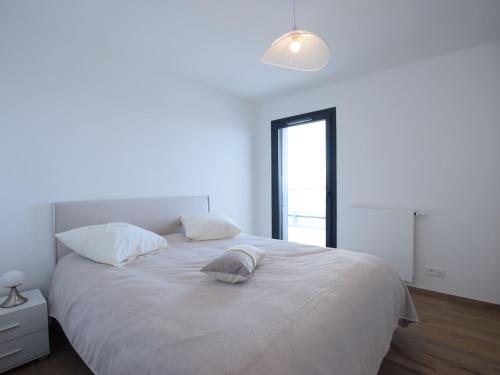 une chambre avec un grand lit blanc avec une fenêtre dans l'établissement Spacieux appartement 4 pers avec balcon, wifi et animaux admis - FR-1-498-101, à Évian-les-Bains