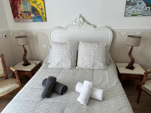 une chambre avec un lit blanc avec deux chaises et deux lampes dans l'établissement Le 108 Appartement, à Nogent-le-Rotrou