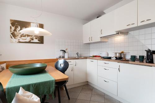 a kitchen with a table with a green bowl on it at Kristiania Apartement Typ B in Siusi