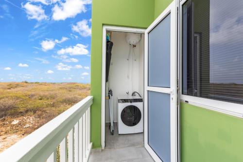 a green house with a washing machine on a balcony at Punta Azul Ocean Resort 5B in Westpunt
