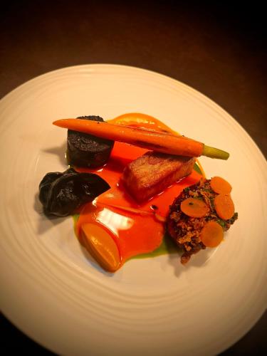 a white plate of food with carrots and other vegetables at Freemasons at Wiswell in Whalley