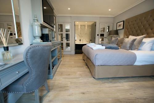 a bedroom with a bed and a desk with a chair at Freemasons at Wiswell in Whalley