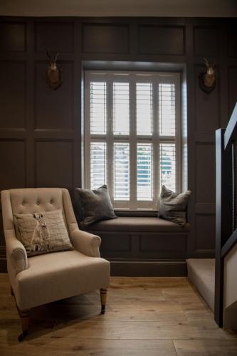 a living room with a window seat and a chair at Freemasons at Wiswell in Whalley