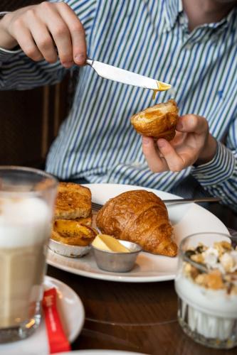 a person holding a piece of food on a plate at The Diamond Amsterdam in Amsterdam