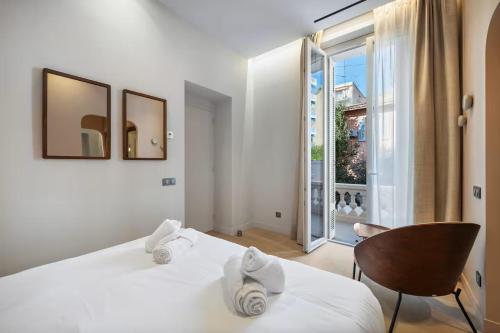 une chambre avec un lit blanc et une grande fenêtre dans l'établissement Appartement 3 chambres avec jardin privé, à Cannes