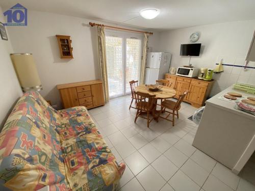 un salon avec un canapé et une cuisine avec une table dans l'établissement Pavillon 6 pers, à 70m plage, 2 chambres, parking - FR-1-781-58, à Valras-Plage
