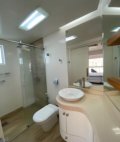 a bathroom with a toilet and a sink and a shower at 3 Dorm. Frente Mar com Churrasqueria #16 in Balneário Camboriú