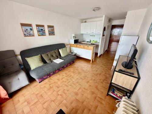 un salon avec un canapé et une cuisine dans l'établissement Studio confortable au Cap d'Agde, proche plage, 4 pers - FR-1-723-46, au Cap d'Agde