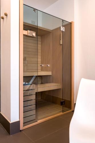 a wardrobe with glass doors in a bedroom at Mercatovecchio Luxury Suites in Udine