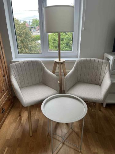 two chairs and a table and a lamp in a room at Ilmarise Apartment in Viljandi