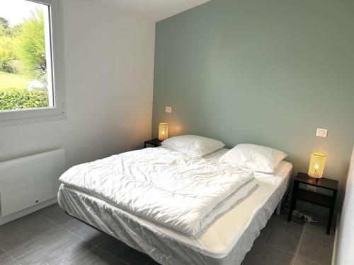 - un lit blanc dans une chambre avec fenêtre dans l'établissement Maison 2 pièces avec mezzanine à Bretignolles-sur-Mer, piscine chauffée, proche mer et centre - FR-1-224A-56, à Bretignolles-sur-Mer