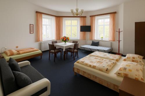 a hotel room with two beds and a table and chairs at Vila Šebest in Volary