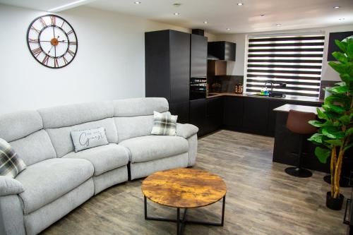a living room with a couch and a clock on the wall at Luxury 2 Bed West London, Free Parking in Uxbridge