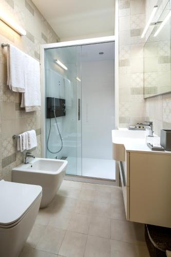 a bathroom with a shower and a sink and a toilet at Mercatovecchio Luxury Suites in Udine