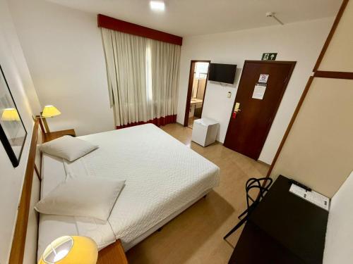 a small room with a bed and a television at César Park Hotel in Juiz de Fora