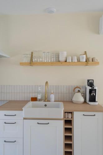 a kitchen with white cabinets and a sink at La Forge in Cassel