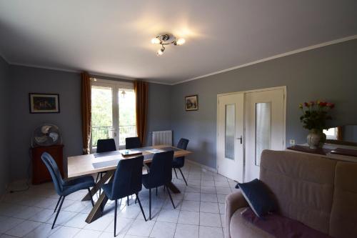 un salon avec une table et des chaises de salle à manger dans l'établissement Maison pour 5 personnes à la campagne, à Blanquefort-sur-Briolance