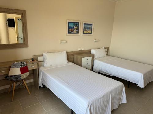 a room with two beds and a desk and a mirror at Bahía - 30º hotels in Puerto de Mazarrón
