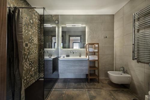 a bathroom with a shower and a tub and a sink at La Glycine in Castro Marim
