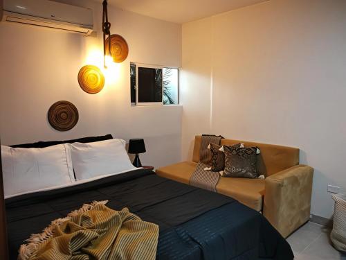 a bedroom with a bed and a couch at Hotel Boutique Tierra Del Mar Cartagena in Cartagena de Indias