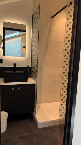 a bathroom with a shower with a sink and a mirror at Suite sous les toits 25m2 à 1mn du port de CASSIS in Cassis