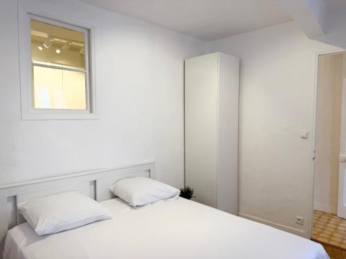une chambre blanche avec un lit et une fenêtre dans l'établissement Charmant 2 pièces proche mer, à Nice