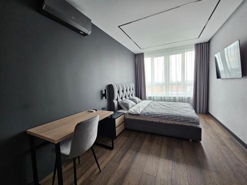 a bedroom with a bed and a desk and a window at Apartment 98 at Park Residence in Lviv