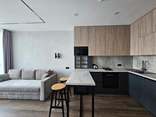 a kitchen and living room with a couch and a table at Apartment 98 at Park Residence in Lviv