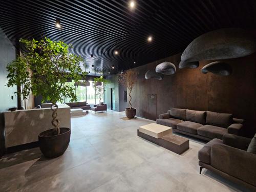 a living room with couches and potted plants at Apartment 98 at Park Residence in Lviv
