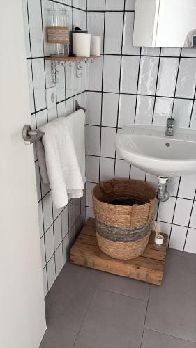 a bathroom with a sink and a basket and a toilet at Barbate Rooms Olehousing in Barbate