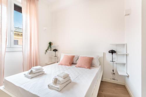 una camera da letto bianca con un grande letto bianco con asciugamani sopra di iFlat Stylish New Flat Steps from the Vatican a Roma