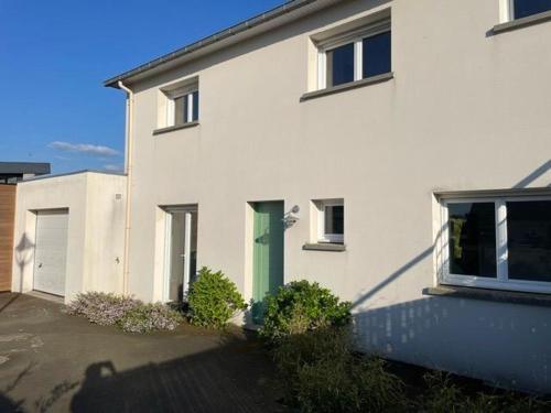une maison blanche avec une porte verte dans l'établissement Appartement RDC Lumineux avec Jardin, à 5 min des plages, à Pléneuf-Val-André