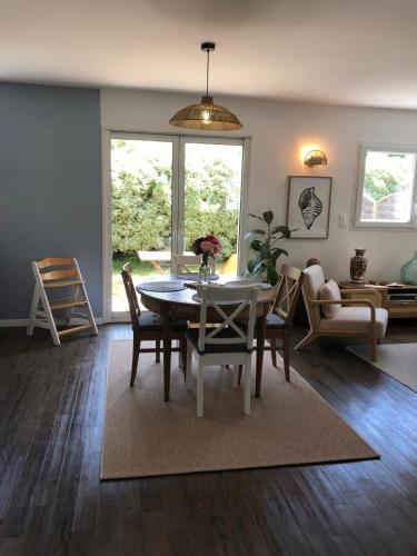 un salon avec une table et des chaises de salle à manger dans l'établissement Appartement RDC Lumineux avec Jardin, à 5 min des plages, à Pléneuf-Val-André