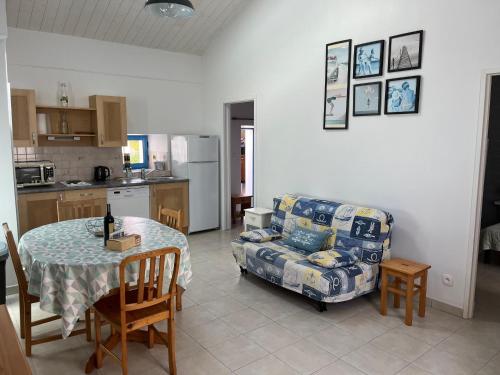 Il dispose d'une cuisine et d'un salon avec une table et un canapé. dans l'établissement Maison mitoyenne à Barbâtre, proche plage, 4 personnes, Wi-Fi, jardin clos - FR-1-823-92, à Barbâtre