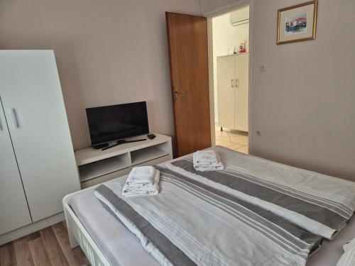 a small bedroom with a bed and a television at Studio Airport Dubrovnik in Čilipi