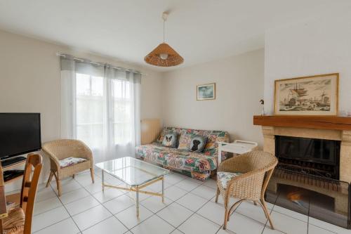 un salon avec un canapé et une cheminée dans l'établissement La Merisolle - 850m mer - Wifi, à Pornic