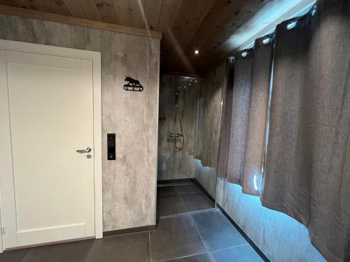 un bagno con una porta bianca e una cabina doccia di Hus nær butikk, sentrum & rekreasjon a Hol