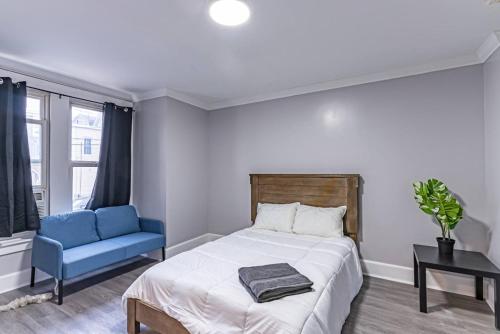 a bedroom with a bed and a blue chair at Private BR Trains EWR USA Mall Penn Station in Newark