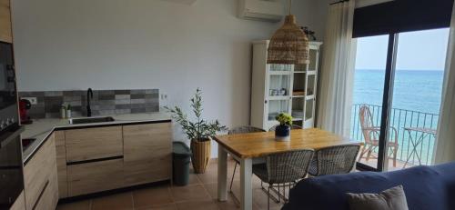 a kitchen with a table and a view of the ocean at Hostal Sa Malica in Blanes