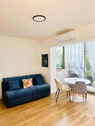 un salon avec un canapé bleu et une table dans l'établissement Golfe Juan Studio Port Camille Rayon Piadon, à Vallauris