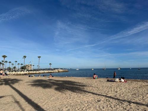 un groupe de personnes sur une plage près de l'eau dans l'établissement Golfe Juan Studio Port Camille Rayon Piadon, à Vallauris