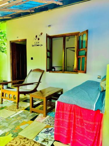 a bedroom with a bed and a chair and a table at Diyakawa Hotel in Arugam Bay