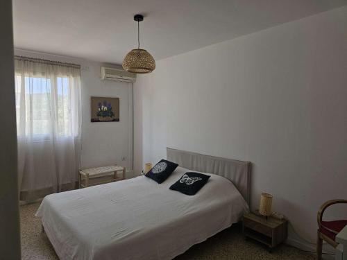 une chambre avec un lit avec deux oreillers dessus dans l'établissement Confortable 2 pièces au Lavandou avec balcon, clim et accès piscine - FR-1-308-120, au Lavandou