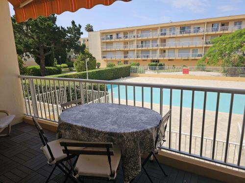 une table et des chaises sur le balcon d'un hôtel dans l'établissement Confortable 2 pièces au Lavandou avec balcon, clim et accès piscine - FR-1-308-120, au Lavandou