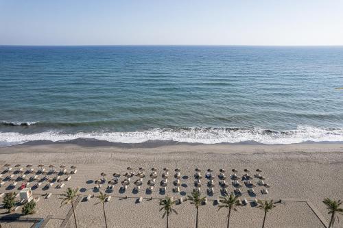 an overhead view of a beach with chairs and the ocean at Caldera Beach in Plataniás