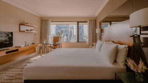 a hotel room with a large bed and a large window at InterContinental Brisbane by IHG in Brisbane