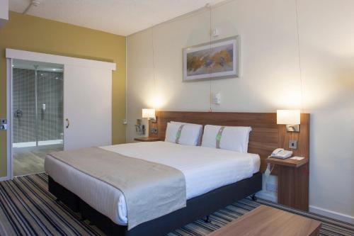 a bedroom with a large bed in a hotel room at Holiday Inn Norwich North by IHG in Norwich