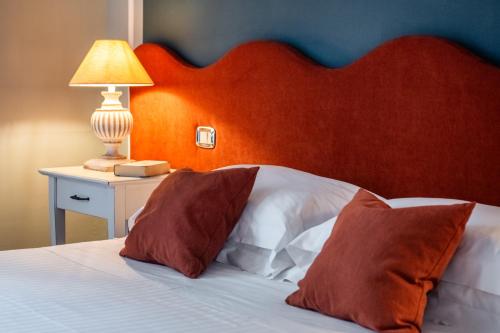 a bed with a red headboard and two pillows at San Giovanni Terme Rapolano in Rapolano Terme